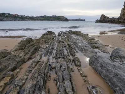 primer-plano-orilla-acantilado-cerca-mar-ondulado-cielo-nublado_181624-48718