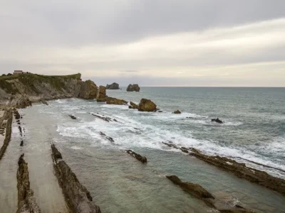 primer-plano-orilla-acantilado-cerca-mar-ondulado-cielo-nublado_181624-49400